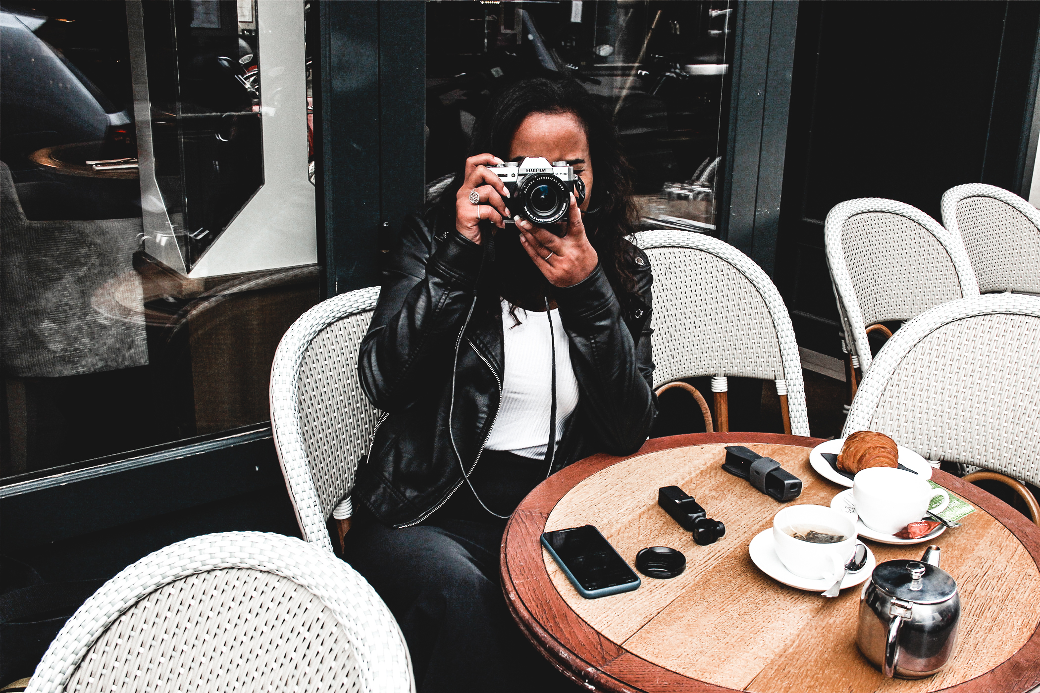 Travel girl in Paris, using Fujifilm TX 30 & DJI Osmo pocket camera to make video and wonderful photography. Setting at a Parisian Cafe